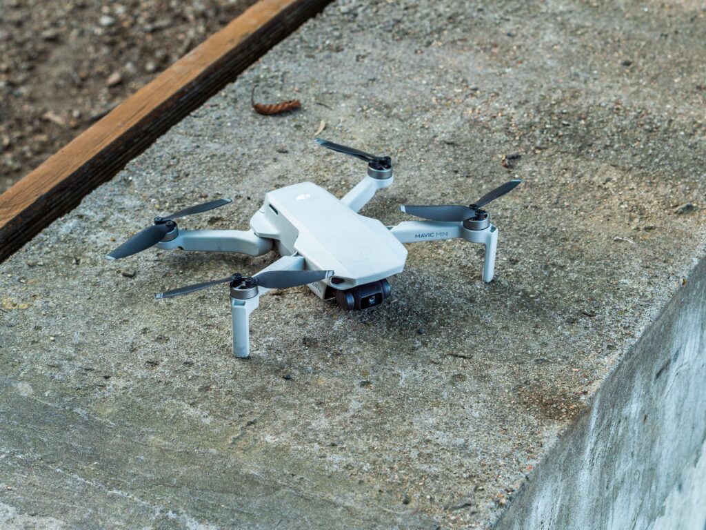 A close-up image of a compact drone resting on a concrete surface.